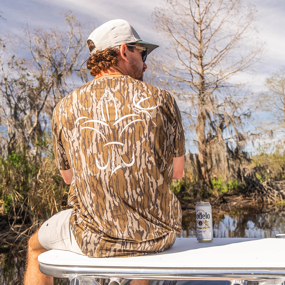 Mossy Oak Bottomland Men’s bamboo cotton stretch pocket T-shirt with Sportsman logo, featuring UPF 50+ sun protection, moisture-wicking breathable fabric, and a flattering fit for hunting, fishing, hiking, and outdoor performance wear.