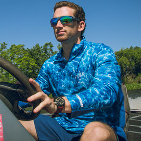 Sportsman cool breeze quarter zip long sleeve performance fishing shirt blue and white - deer duck fish hook fleur-de-lis logo - action shot on bass boat